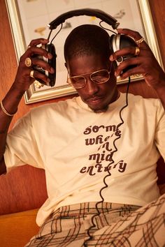 a man sitting on a bed with headphones in his ears