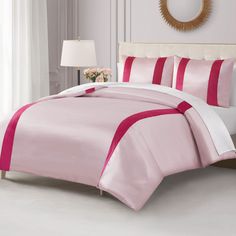 a bed with pink and white comforters in a room