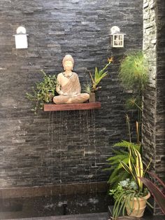 a buddha statue sitting on top of a shelf next to plants