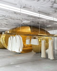 there is a large gold object with clothes hanging from it's sides in the room