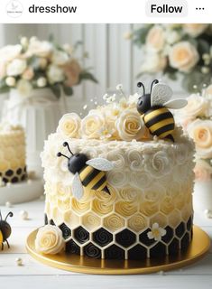 there is a cake decorated with flowers and two bees on the top one has yellow icing