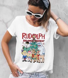 a woman wearing a rudolph christmas t - shirt while holding her hands on her head