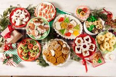 a table topped with lots of different types of food and snacks on plates next to each other