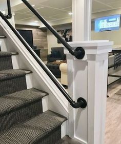 the stairs in this house are made of wood and have black handrails that lead up to the second floor