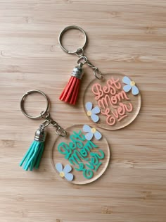 two keychains with the words best mom ever and tassels on them