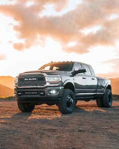 a large gray truck parked on top of a dirt field