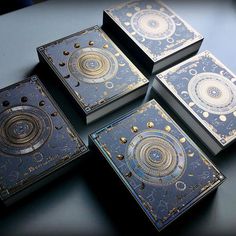 four decorative boxes sitting on top of a table