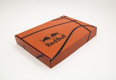 an orange and black basketball sitting on top of a white table next to a box