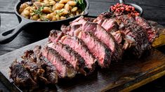 steak, potatoes and salad on a wooden cutting board