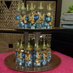 there are many small bottles with blue and gold decorations on top of the cake plate