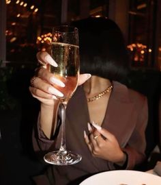 a woman sitting at a table with a glass of wine