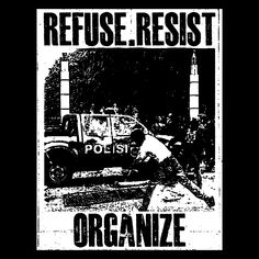 a police car parked on the side of a road next to a sign that reads refuse resist organize