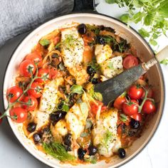 a pan filled with chicken, tomatoes and olives