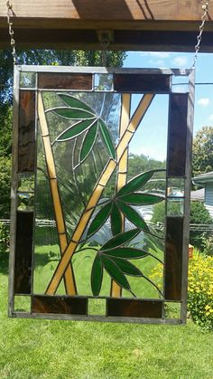 a stained glass window hanging from the side of a wooden structure in front of a house