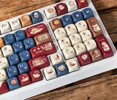 a close up of a keyboard on a wooden surface with many different colors and designs