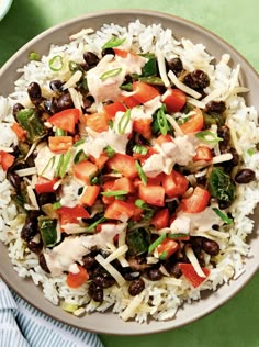 a bowl filled with rice, beans and other vegetables on top of a green table