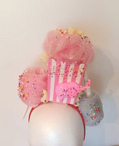 If you want to bring a smile to everyone you see, try wearing this Retro Style Headband! 🍿 This is done on a red headband but feel free to request a different Color! 🍿The pink/white Striped cardboard container stands 5.75 inches high and is filled with fake pink Cotton Candy,round Sprinkles, and a few Popcorn kernels. 🍿 The front of the container there is a pink animal Cookie, and popcorn kernels.  🍿 And your right side is a light pink cotton candy and on your left will be an upside down light blue cotton candy on a white cone with colorful beads. Everything is held in place very secure!!   You will see in a picture a ribbon attachment in the back of the headband where you can place a hair clip or bobby pins to hold it securely if needed. Adjustable Novelty Headpieces For Carnival, Novelty Adjustable Headpiece For Carnival, Donut Headband, Candy Headpiece, Candy Headband, Cotton Candy Headband, Cotton Candy Halloween Costume, Cotton Candy Costume, Carnival Dress