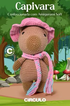 a crocheted teddy bear wearing a pink hat and scarf in front of trees