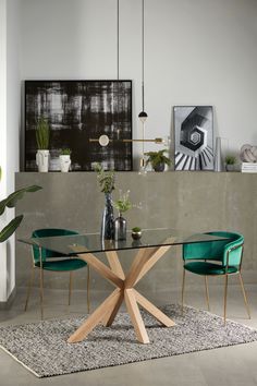 a glass table with wooden legs and green chairs