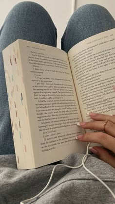 a woman is reading a book while laying down