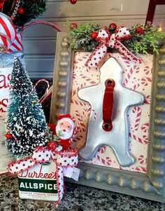 christmas decorations are displayed in front of an old frame with a gingerbread man on it