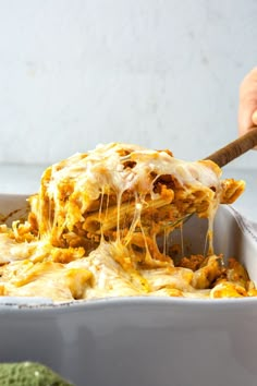 a person scooping some food out of a casserole dish