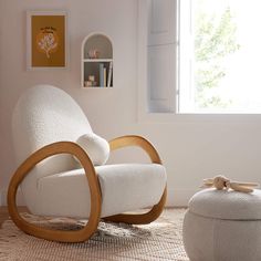 a white rocking chair and ottoman in a living room with a large window behind it