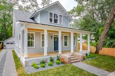 a gray house with white trim and yellow accents