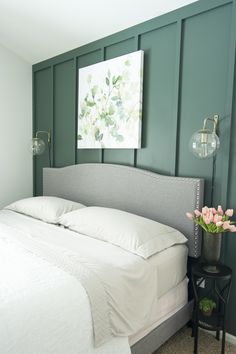 a bedroom with green walls and white bedding