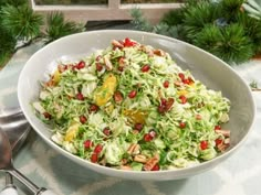 a white bowl filled with coleslaw and oranges on top of a table