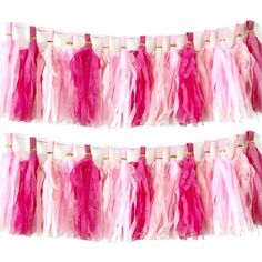 two rows of pink and white streamers hanging from the side of a wall with gold pins