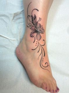 a woman's foot with a flower tattoo on it