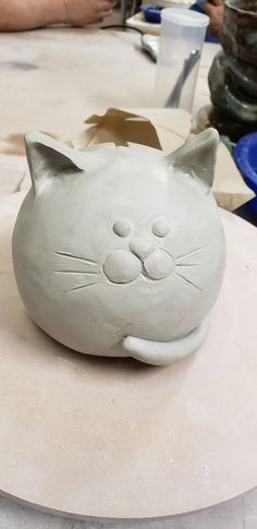 a white ceramic cat sitting on top of a table