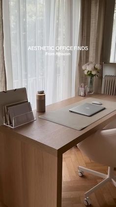 an office desk with a laptop on it in front of a window and white chairs