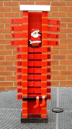 a red and white clock sitting on top of a table next to a brick wall