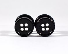 two black buttons sitting on top of each other