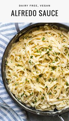 a skillet filled with alfredo sauce on top of a blue and white striped towel