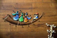 decorative wall hangings on the side of a wooden floor, depicting people in a boat