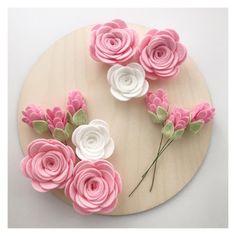 some pink and white flowers on a wooden board