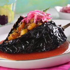 a white plate topped with a piece of food on top of a pink table cloth