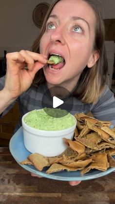 a woman eating guacamole and tortilla chips