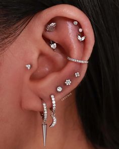 a woman's ear with three different piercings