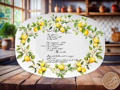 a white plate with yellow lemons and green leaves on it, sitting on a wooden table