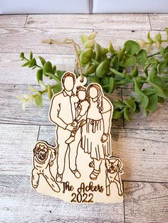 a wooden ornament with an image of a couple and their dog