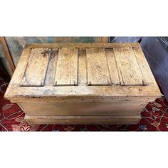 an old wooden box sitting on top of a rug