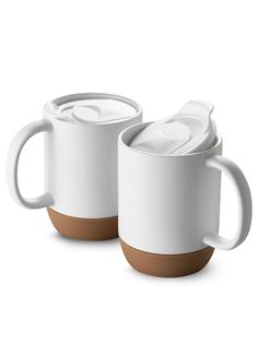 two white coffee mugs with brown lids