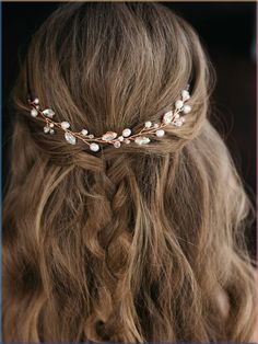 a woman with long hair wearing a gold headband and pearls on it's side