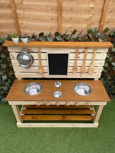 an outdoor kitchen made out of pallet wood with pots and pans on top