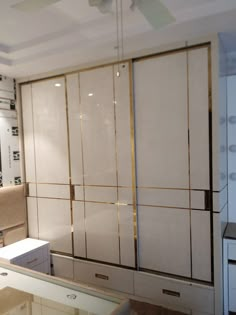 an empty room with white and gold closets in the corner, including a mirror