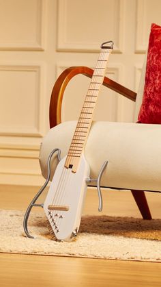 an electric guitar sitting on top of a white chair